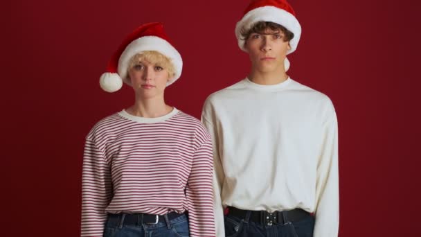 Młoda Niezadowolona Dziewczyna Bratem Boże Narodzenie Santa Kapelusz Pokazuje Stop — Wideo stockowe