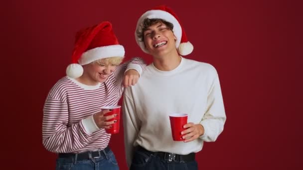 Jovem Rindo Menina Com Seu Irmão Natal Santa Chapéu Beber — Vídeo de Stock