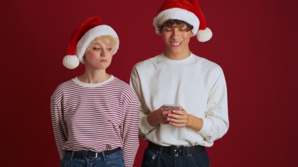 Joven Linda Chica Mirando Hermano Navidad Sombrero Santa Que Chatea — Vídeos de Stock