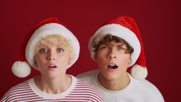 Joven Chica Linda Concentrada Con Hermano Navidad Sombrero Santa Mirando — Vídeos de Stock