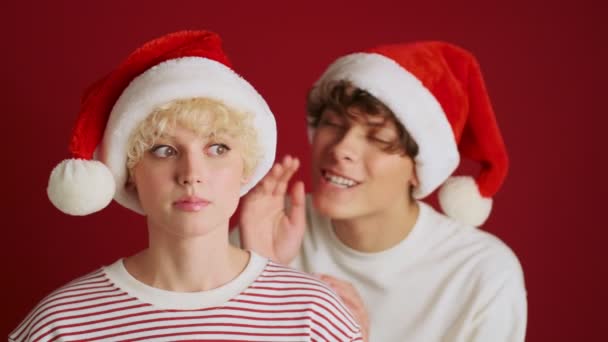 Joven Sorprendida Linda Chica Chismorreando Con Hermano Navidad Sombrero Santa — Vídeos de Stock