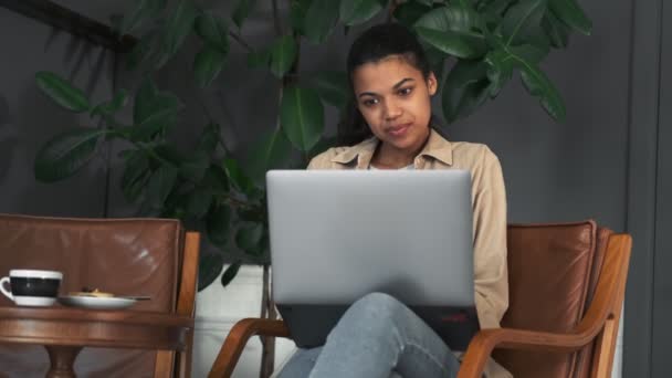 Красивая Африканская Американская Девушка Использует Свой Ноутбук Сидя Кресле Кафе — стоковое видео