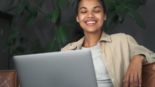 Una Sorridente Ragazza Afroamericana Sta Usando Suo Computer Portatile Seduto — Video Stock