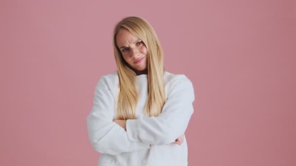 Ображена Блондинка Перетинає Руки Стоячи Ізольовано Рожевому Фоні Студії — стокове відео