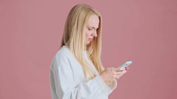 Sidovy Missnöjd Nervös Blond Kvinna Använder Sin Smartphone Stående Isolerad — Stockvideo