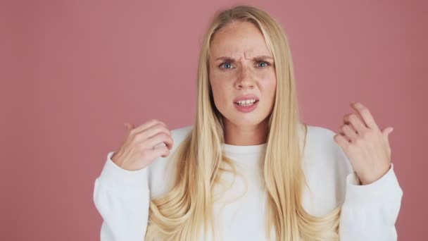 Femeie Blondă Confuză Ridică Mâinile Picioare Izolată Fundal Roz Studio — Videoclip de stoc
