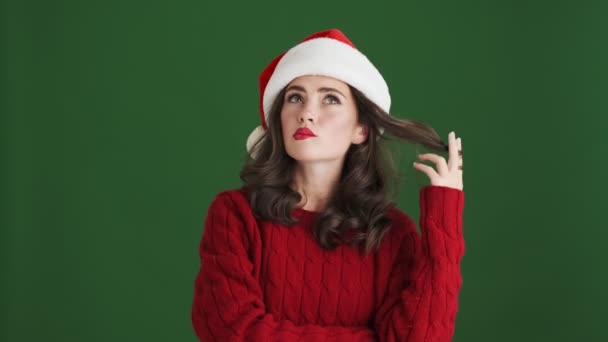 Pretty Thinking Girl Christmas Santa Hat Isolated Green Wall Background — Stock Video