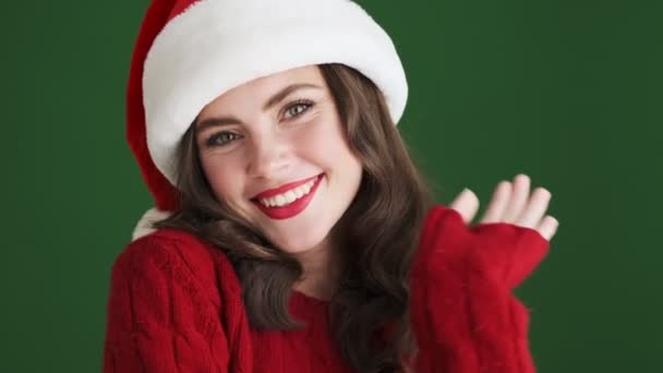 Vrolijk Optimistisch Meisje Kerst Santa Hoed Geïsoleerd Groene Muur Achtergrond — Stockvideo