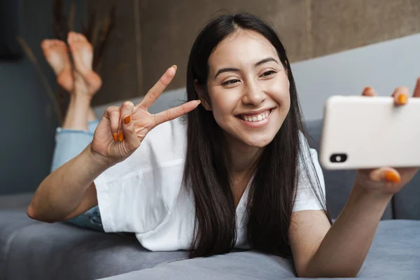 Obraz Wesołej Młodej Kobiety Domu Leżącej Kanapie Robiącej Selfie Przez — Zdjęcie stockowe