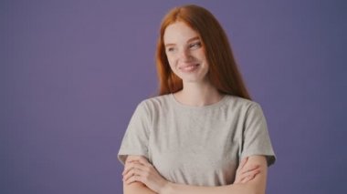 Güzel bir genç kadın gülüyor menekşe bir arka planda yalnız duruyor.