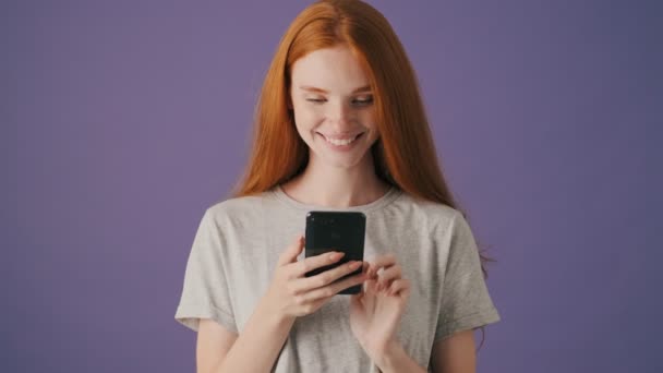 Positive Young Woman Typing Her Smartphone Standing Isolated Violet Background — Stock Video