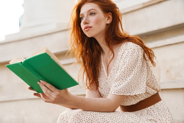 Bild Von Fokussiertem Ingwermädchen Mit Strohhut Das Buch Liest Während — Stockfoto