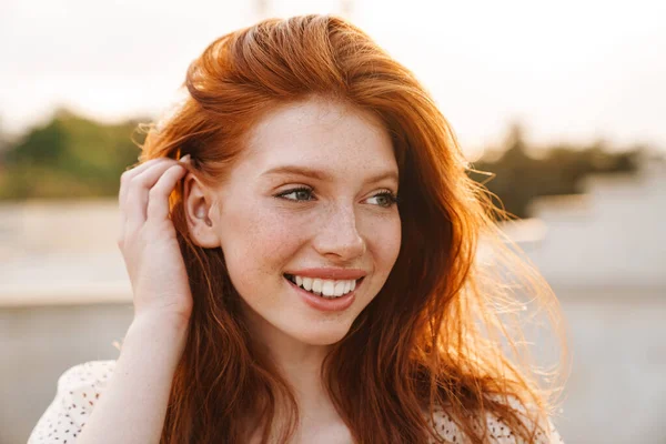 Εικόνα Του Χαρούμενου Ginger Girl Χαμογελώντας Και Κοιτάζοντας Στην Άκρη — Φωτογραφία Αρχείου