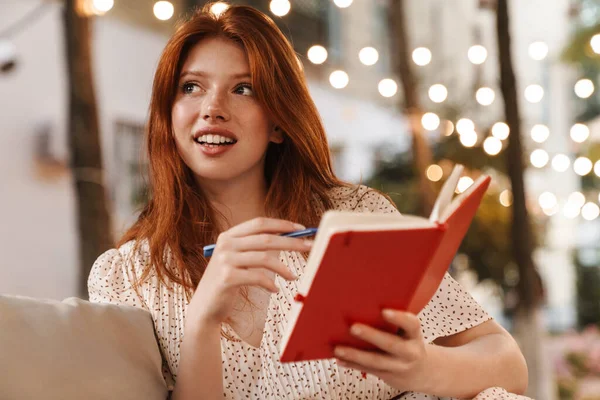 Immagine Gioiosa Ragazza Rossiccia Che Sorride Annota Mentre Siede Nel — Foto Stock