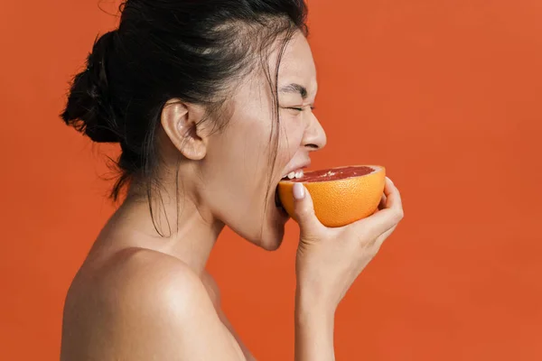 Bild Tröjlös Asiatisk Vacker Flicka Äter Grapefrukt Isolerad Över Orange — Stockfoto