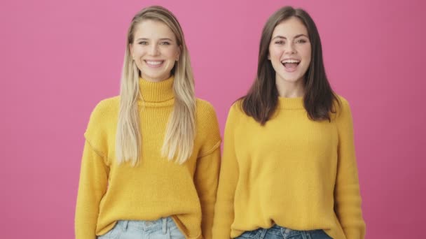 Mosolygó Nők Sárga Pulóverben Bólogatnak Miközben Rózsaszín Háttér Felett Álló — Stock videók