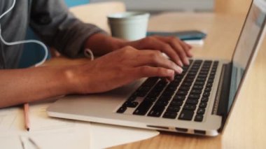 Afrikalı bir kadının evde oturup dizüstü bilgisayar kullanırken çekilmiş videosu.