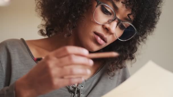 Mujer Africana Concentrada Sentada Casa Escribiendo Notas — Vídeo de stock