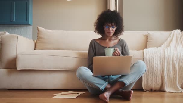 Geconcentreerde Tevreden Afrikaanse Vrouw Zitten Binnen Thuis Met Behulp Van — Stockvideo