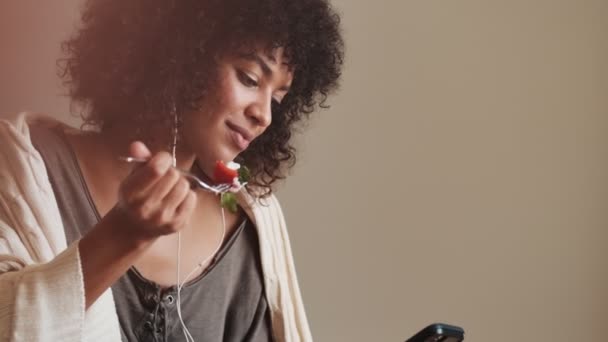 Plaisir Concentré Femme Africaine Intérieur Maison Utilisant Téléphone Portable Écouter — Video