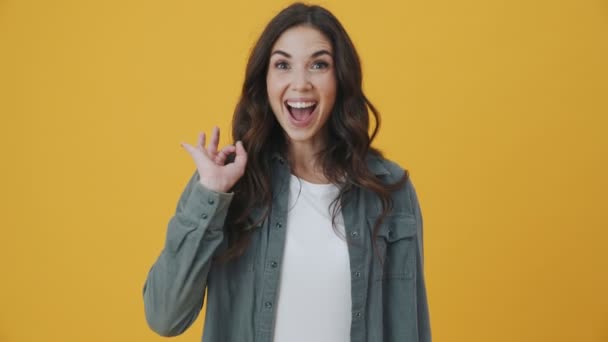 Задоволена Жінка Посміхається Робить Нормальний Жест Стоїть Ізольовано Жовтому Тлі — стокове відео