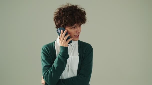 Jeune Homme Positif Parle Sur Son Smartphone Tout Faisant Geste — Video