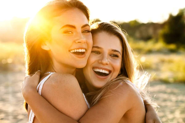 Dos Jóvenes Caucásicas Felices Mujeres Sonriendo Abrazándose Juntas Mientras Caminan —  Fotos de Stock