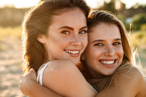 Dos Jóvenes Caucásicas Felices Mujeres Sonriendo Abrazándose Juntas Mientras Caminan —  Fotos de Stock