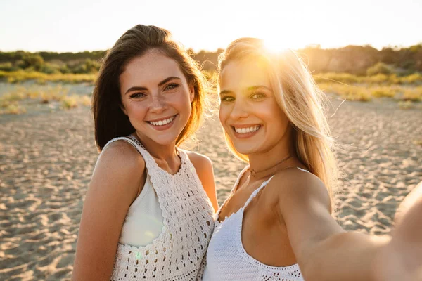 Δύο Νεαρές Καυκάσιες Χαρούμενες Γυναίκες Χαμογελούν Και Βγάζουν Selfie Ενώ — Φωτογραφία Αρχείου