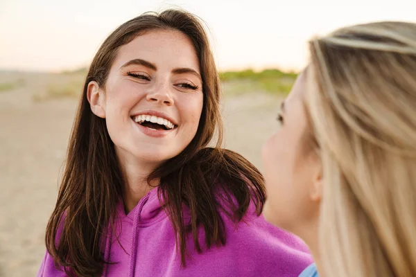 Dos Jóvenes Caucásicas Mujeres Felices Sonriendo Mirándose Mientras Caminan Playa —  Fotos de Stock