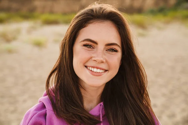 Young caucasian happy woman smiling and looking at camera while walking outdoors