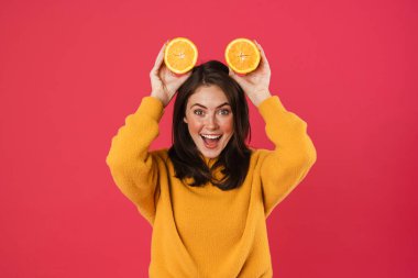 Pembe arka planda turuncuyla dalga geçen neşeli beyaz kız görüntüsü