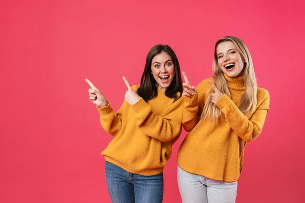 Imagen Hermosas Mujeres Emocionadas Sonriendo Mientras Señalan Los Dedos Lado — Foto de Stock