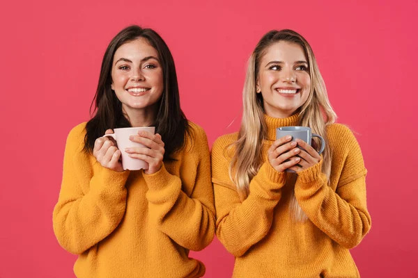 ピンクの背景に隔離されたカメラでコーヒーを飲みながら笑顔の素敵な女性のイメージ — ストック写真