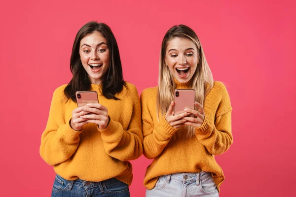 Imagen Mujeres Encantadas Sonriendo Mientras Usa Teléfonos Inteligentes Aislados Sobre — Foto de Stock