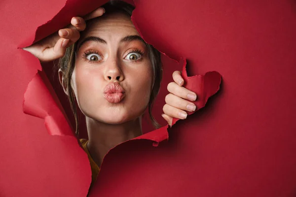 Кавказька Молода Щаслива Жінка Робить Поцілунок Фотоапараті Через Червоний Фон — стокове фото