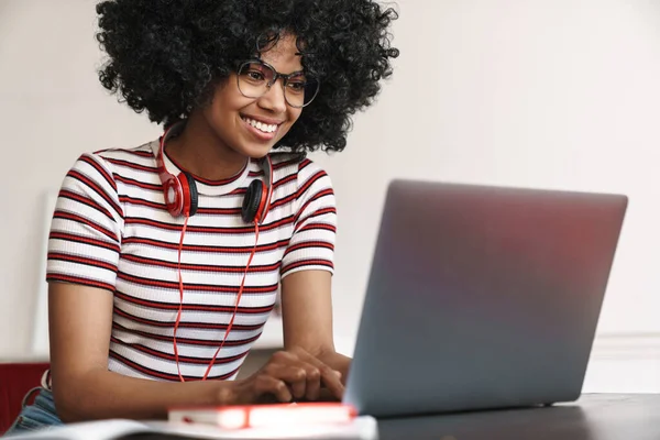 Sonriendo Chica Estudiante Afroamericana Haciendo Tarea Con Ordenador Portátil Mientras —  Fotos de Stock