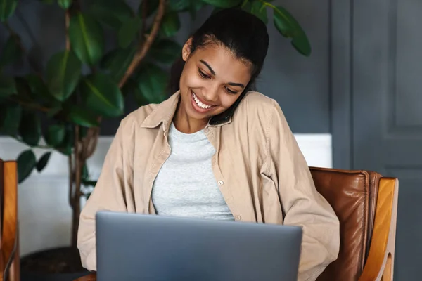 Alegre Mujer Afroamericana Hablando Por Teléfono Celular Mientras Trabaja Con —  Fotos de Stock