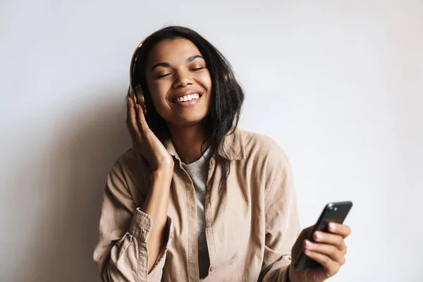 Mujer Afroamericana Feliz Escuchando Música Con Auriculares Teléfono Celular Aislado — Foto de Stock