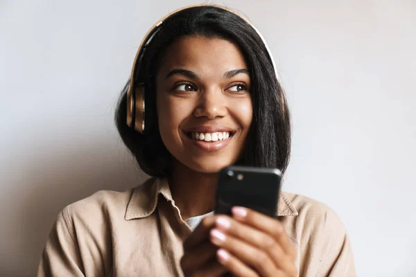 Onnellinen Afrikkalainen Amerikkalainen Nainen Kuuntelee Musiikkia Kuulokkeet Matkapuhelin Eristetty Valkoisella — kuvapankkivalokuva