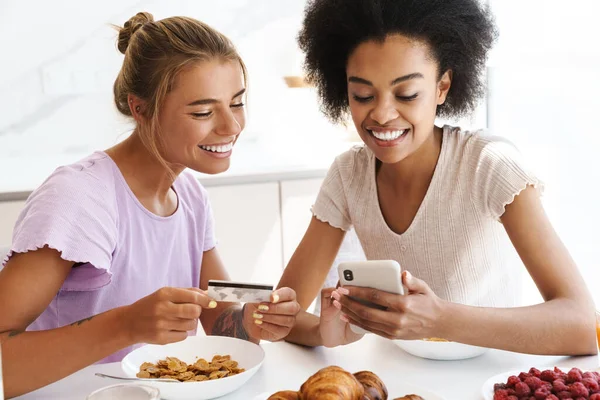Niza Chicas Multiculturales Utilizando Teléfono Celular Tarjeta Crédito Mientras Desayunan — Foto de Stock