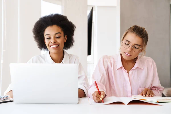 Hermosas Estudiantes Multiculturales Niñas Haciendo Tarea Con Ordenador Portátil Juntos —  Fotos de Stock