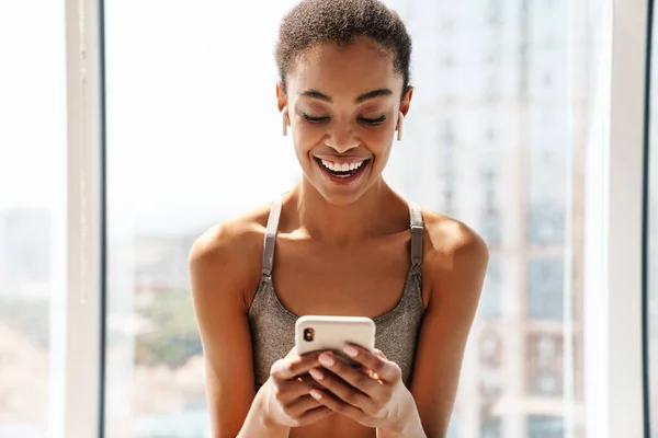 Foto Uma Jovem Sorridente Mulher Africana Esportes Felizes Usando Telefone — Fotografia de Stock