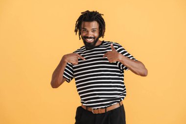Gülümseyen Afrikalı Amerikalı adamın sarı arka planda kendini gösteren fotoğrafı.