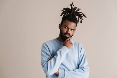 Kara kara düşünen Afrikalı Amerikalı adam beyaz arka planda izole edilmiş bir şekilde düşünüyor ve bir kenara bakıyor.