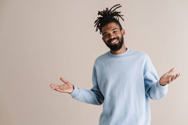 Beyaz arka planda yalnız bırakılmış elleri kusan mutlu Afro-Amerikalı adam.