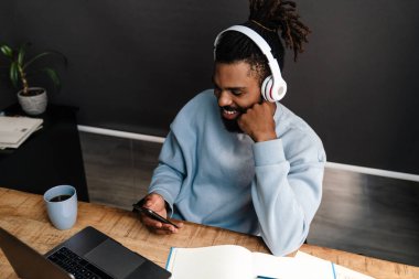 Masada çalışan kendinden emin Afrikalı serbest çalışan genç bir adam.