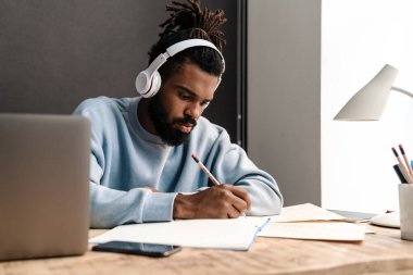 Masada çalışan kendinden emin Afrikalı serbest çalışan genç bir adam.