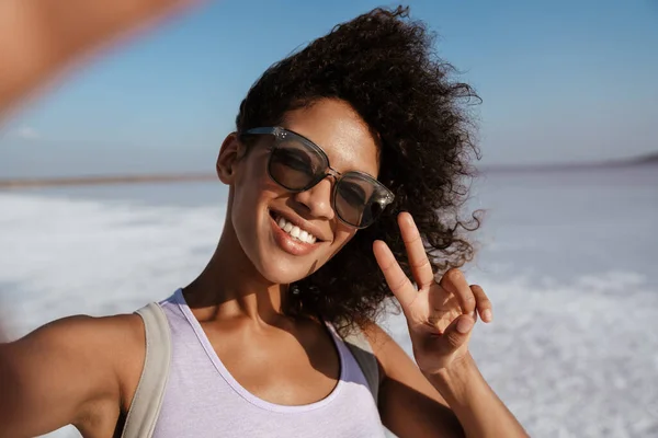Obraz Szczęśliwej Afroamerykanki Gestykulującej Znak Pokoju Podczas Robienia Selfie Salt — Zdjęcie stockowe