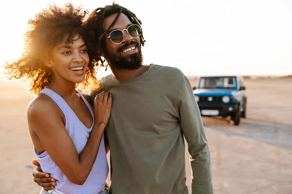 Imagem Alegre Casal Afro Americano Abraçando Caminhando Enquanto Viaja Carro — Fotografia de Stock